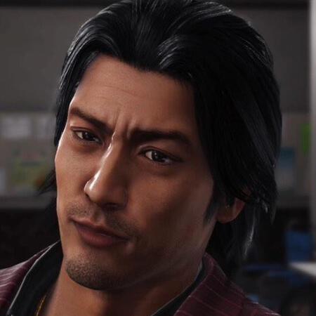 Akiyama Shun, tilting his head. He has black hair and stubble facial hair. A bit of his suit collar shows.